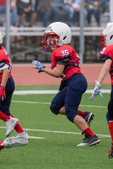 Young athletic boy playing in a youth tackle football game
