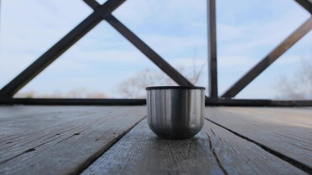 Filling of a black arabian caffe in a thermos pot made of stainless steel in flood plain bird watching tower in karacabey bursa and then taking of the caffee cup by hand 