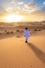 Fototapeta na wymiar Berber man wearing traditional clothes in the Sahara Desert at dawn, Morocco