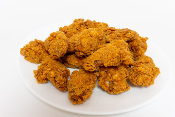 Deep fried spicy chicken wings in a crispy breadingon plate, chicken fast food isolated on white background