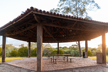 Fototapeta na wymiar cobertura em área de lazer do parque do Carmo sob bancos e mesa. Área de churrasqueira no parque vazia.