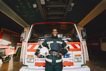 Portrait of a firefighter standing in front of a fire engine