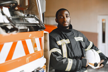 Portrait of a firefighter standing in front of a fire engine