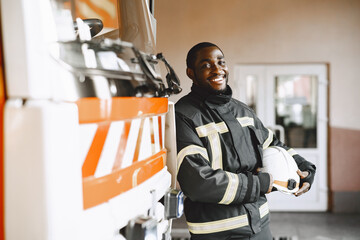 Portrait of a firefighter standing in front of a fire engine