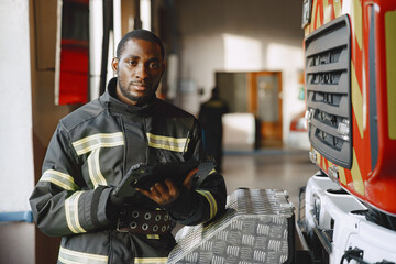 Portrait of a firefighter standing in front of a fire engine