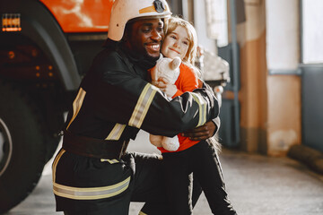 Portrait of a firefighter standing in front of a fire engine