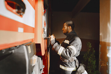 Portrait of a firefighter standing in front of a fire engine