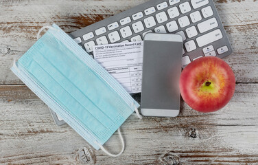 Covid 19 vaccination record card with back to work or school required items during the pandemic