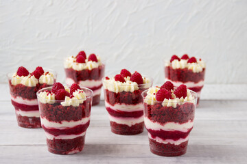 Homemade desserts in a glass, with raspberry jelly, cream and  fresh raspberries.