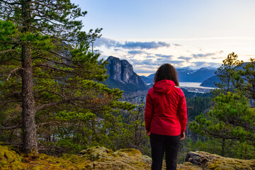 Adventurous Woman Hiking in the mountains during a Spring Sunset. Taken Squamish, North of Vancouver, British Columbia, Canada. Concept: Adventure, freedom, lifestyle