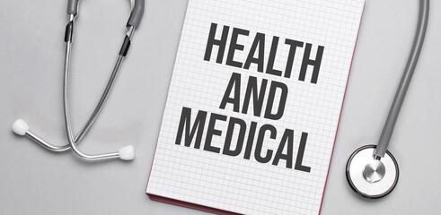 On a beige background, a stethoscope and a white notepad with the inscription health and medical. Medical concept