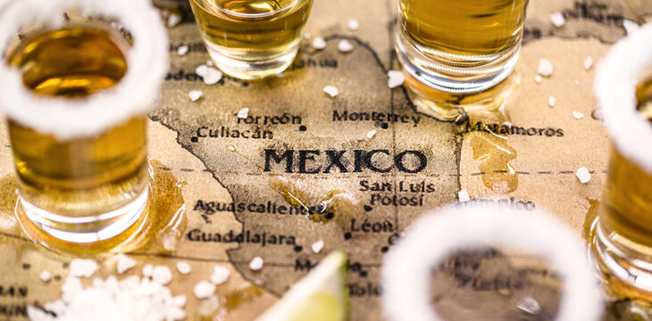 old mexico map with tequila glasses around, selective focus, image in celebration of tequila day