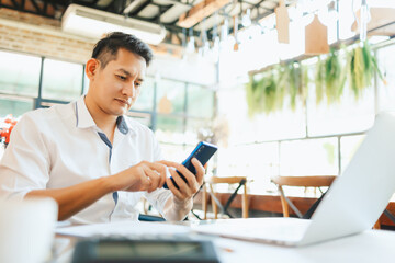 young businessman working and using smart phone and notebook computer in workplace.