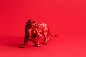 Fototapeten Red lion figure on the red background. Protect wild animals poster.  © zhennyzhenny