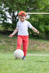 Little boy kicking ball in the park. playing soccer (football) in the park. Sports for exercise and activity.