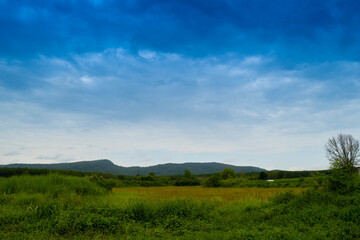 landscape view with blue,black,red sky and green mountain.