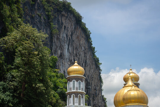 Part of golden dome of Muslim mosque with beautiful view of mountain cliff and blue sky in day time. Religion building photo. 
