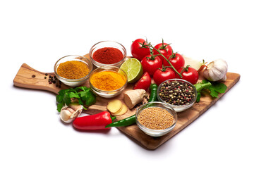 Set of spices and vegetables on wooden serving board on white background