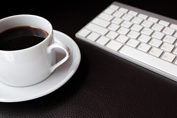 Work from home concept. computer keyboard, cup of coffee on sofa.