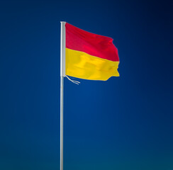 Red and yellow surf lifesaving flag on blue background
