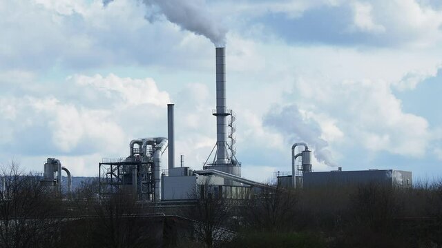 smoking chimney of a factory against sky in Germany
