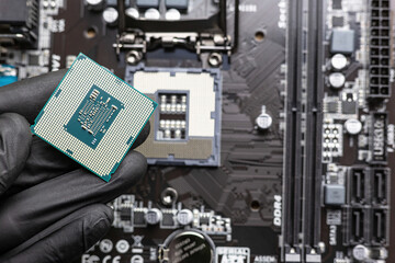 Central processing unit (central processing unit) in a man's hand in a black glove - close-up, with...