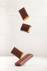 Different energy protein bar on grey background. Flying levitation