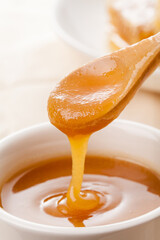 sugared honey dripping from a wooden spoon.