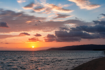 Fototapeta na wymiar Dawn with colorful sky, the sun rising on the horizon, a serene sea, cirrus and cumulonimbus painting the sky of Nakano beach. Iriomote Island.