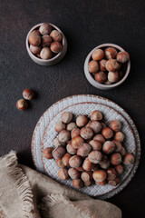 Unpeeled hazelnuts in ceramic dishes. Cotton napkin. Natural protein.Vertical photo.Top view.