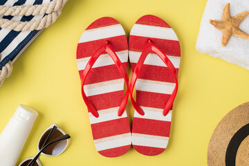 Top view photo of beach bag towel starfish hat cream bottle sunglasses striped red and white flip-flops on isolated pastel yellow background,