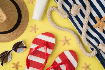 Gordijnen Top view photo of sunhat cream bottle beach bag striped flip-flops sunglasses and starfishes on isolated pastel yellow background © ActionGP