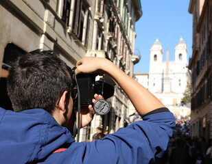 young photographer taking a souvenir photo at the church of Trinita dei Monti in Rome Capital of Italy