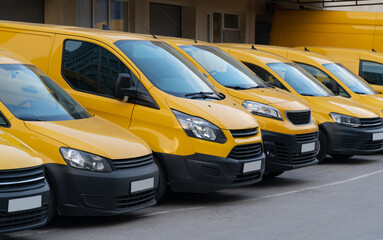 Fototapeta na wymiar Yellow delivery vans parked in a row 