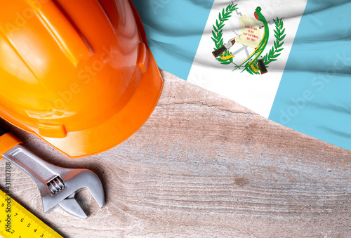 Guatemala flag with different construction tools on wood background, with copy space for text. Happy Labor day concept.