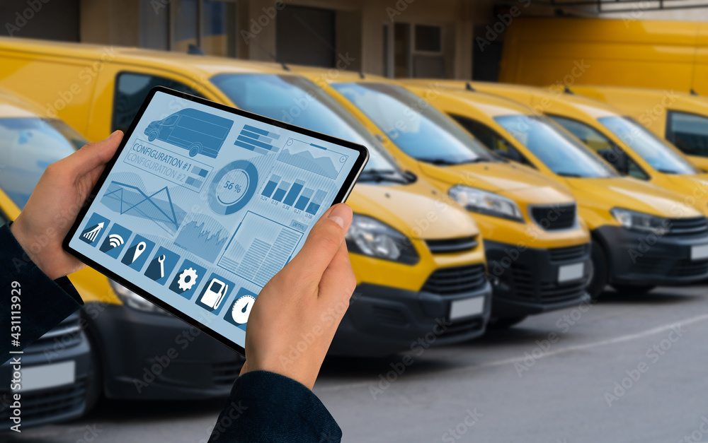 Poster Manager with a digital tablet on the background of vans. Fleet management	