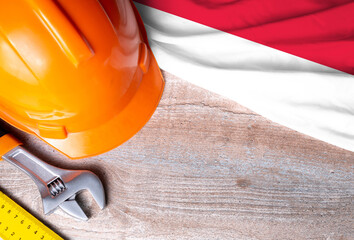 Indonesia flag with different construction tools on wood background, with copy space for text. Happy Labor day concept.