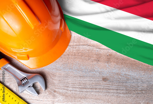 Hungary flag with different construction tools on wood background, with copy space for text. Happy Labor day concept.