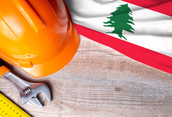 Lebanon flag with different construction tools on wood background, with copy space for text. Happy Labor day concept.