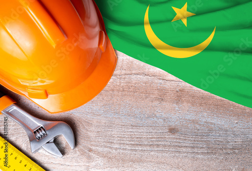 Mauritania flag with different construction tools on wood background, with copy space for text. Happy Labor day concept.