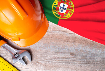 Portugal flag with different construction tools on wood background, with copy space for text. Happy...