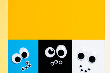 Smileys from toy eyes on hermetic multi-colored background