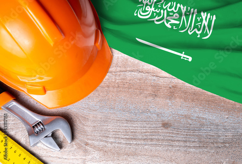 Saudi Arabia flag with different construction tools on wood background, with copy space for text. Happy Labor day concept.