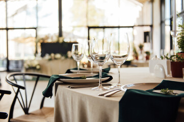 Luxurious restaurant. Luxurious interior, white tables, serving dishes and glasses for guests