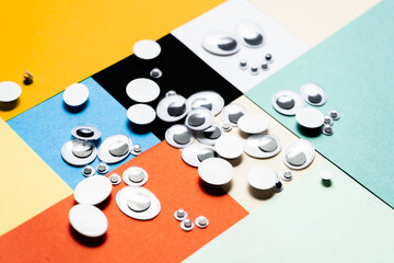 A bunch of toy eyes scattered against a multi-colored background
