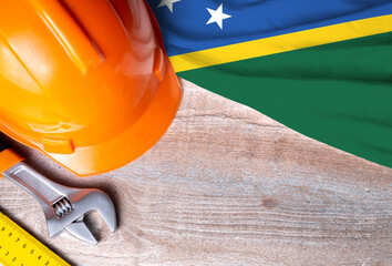 Solomon islands flag with different construction tools on wood background, with copy space for text. Happy Labor day concept.