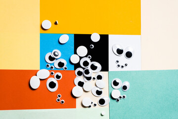 A bunch of toy eyes scattered against a multi-colored background