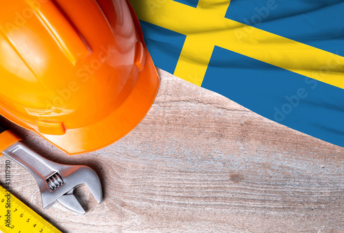 Sweden flag with different construction tools on wood background, with copy space for text. Happy Labor day concept.