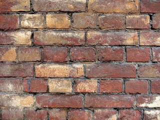 Red brick wall with yellow splinters
