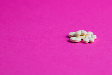 Pills on pink paper background with copy space. Covid 19 treatment concept